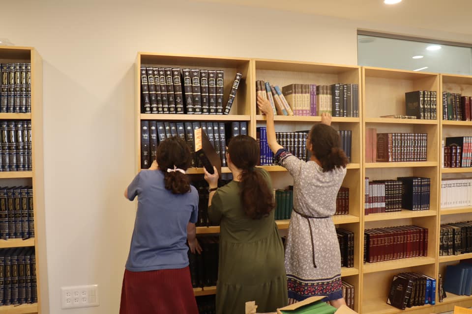 Yeshiva students setting up the new beit midrash
